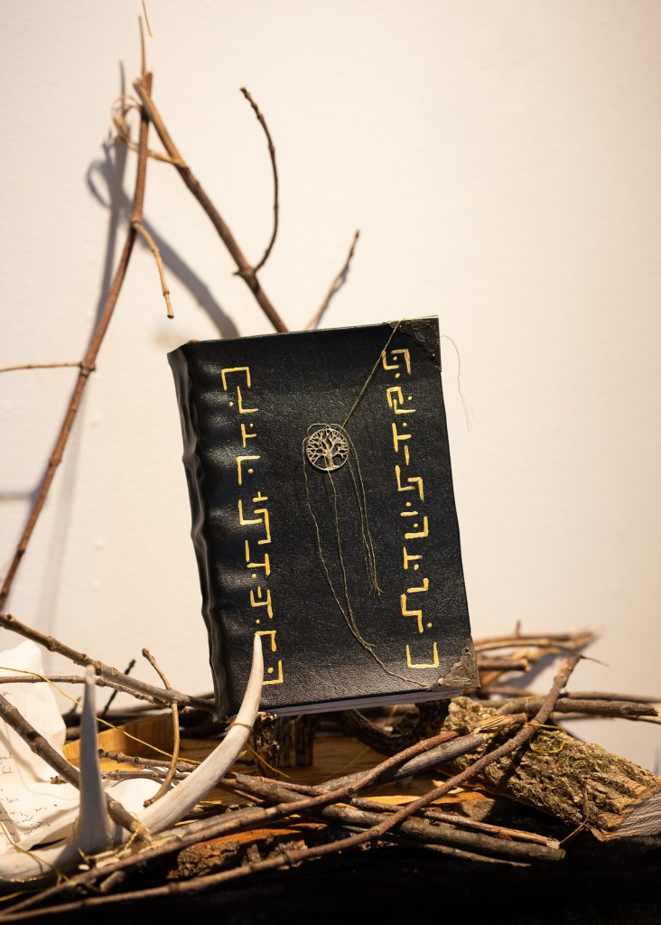 Woven Thread in its gallery exhibit with branches, sticks, and an antler