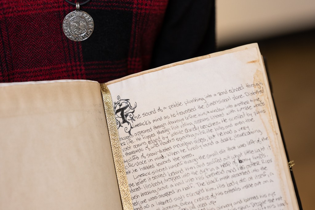 The hand bound book Woven Thread opened to one of the 80+ pages of content inside