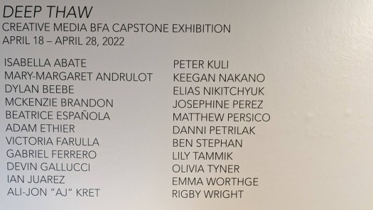 A photo of the wall of student exhibits in the Creative Media Capstone Exhibition Deep Thaw